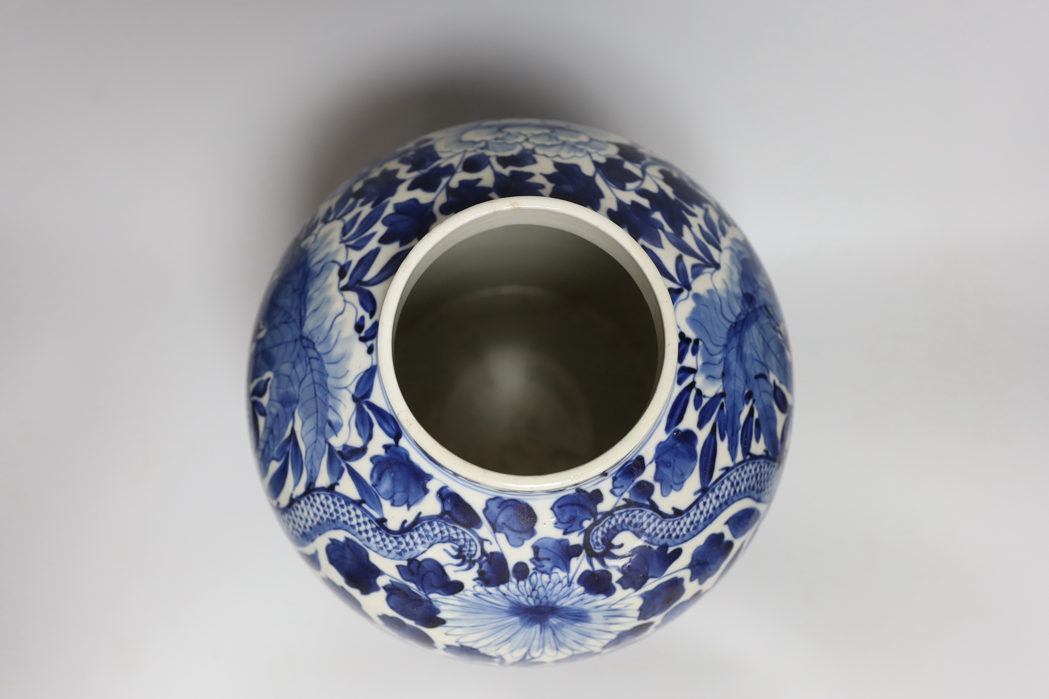 A large Chinese blue and white jar painted with a dragon amongst leaves and flowers, 29cm high